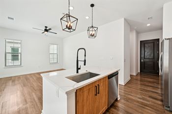 A kitchen with a white counter top and wooden cabinets.